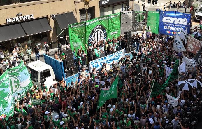 Columna de ATE con banderas verdes y la consigna "El Estado no sobra" movilizada en el centro porteño contra el DNU 70/23