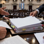 Manos que se pasan pilas de expedientes en el recinto de la Cámara de Diputados