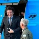 Comitiva oficial desciende del avión presidencial junto a un efectivo de la Fuerza Aérea, en el inicio de la gira federal