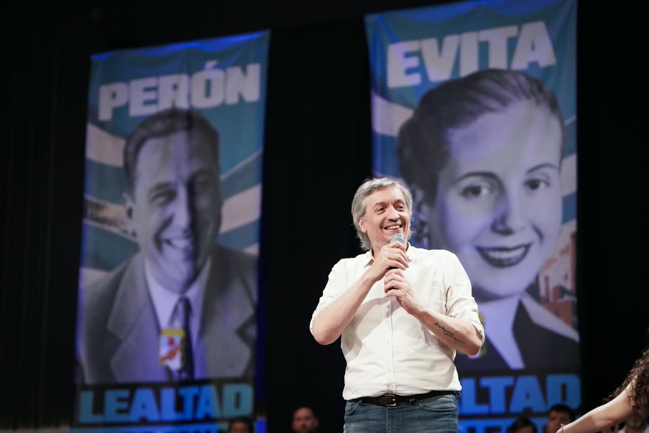 Máximo Kirchner habla con un micrófono frente a banderas de Perón y Evita en Chaco